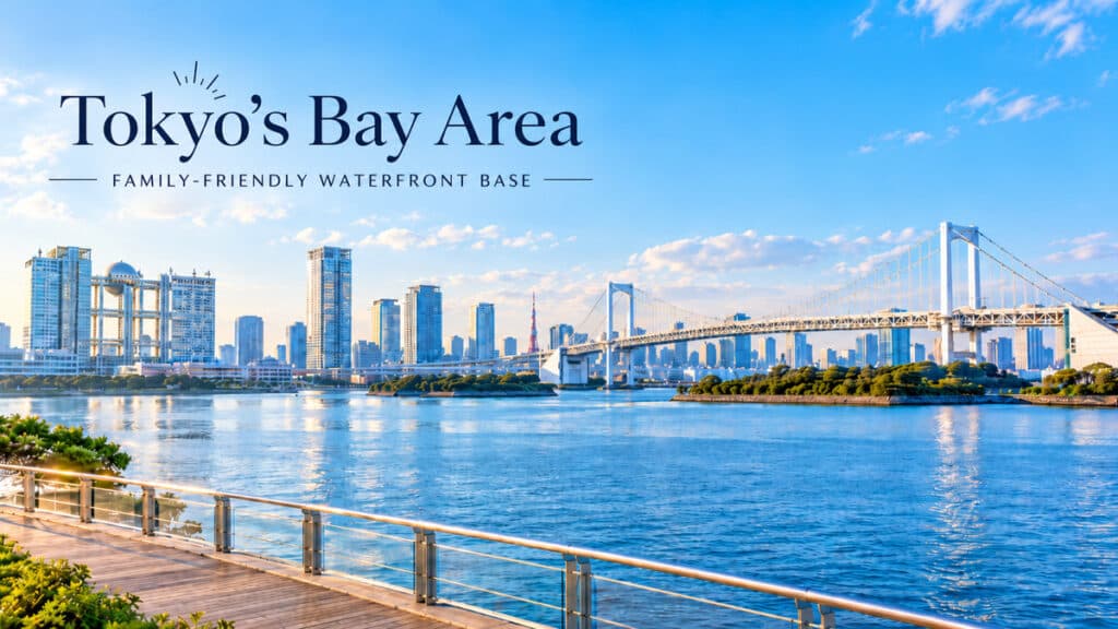 Tokyo Bay waterfront in Odaiba with Rainbow Bridge, modern buildings, and a wide seaside promenade.